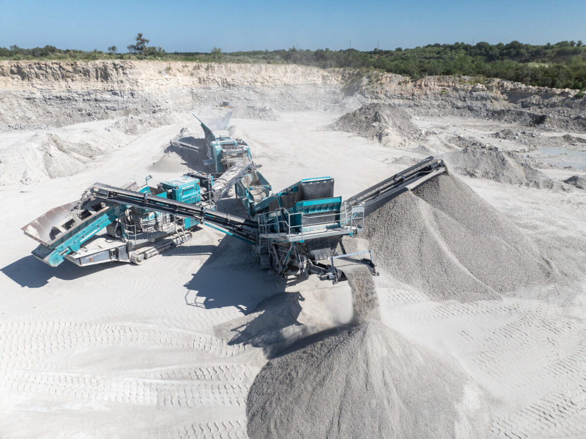 blue machines working and processing crushed stones in a quarry