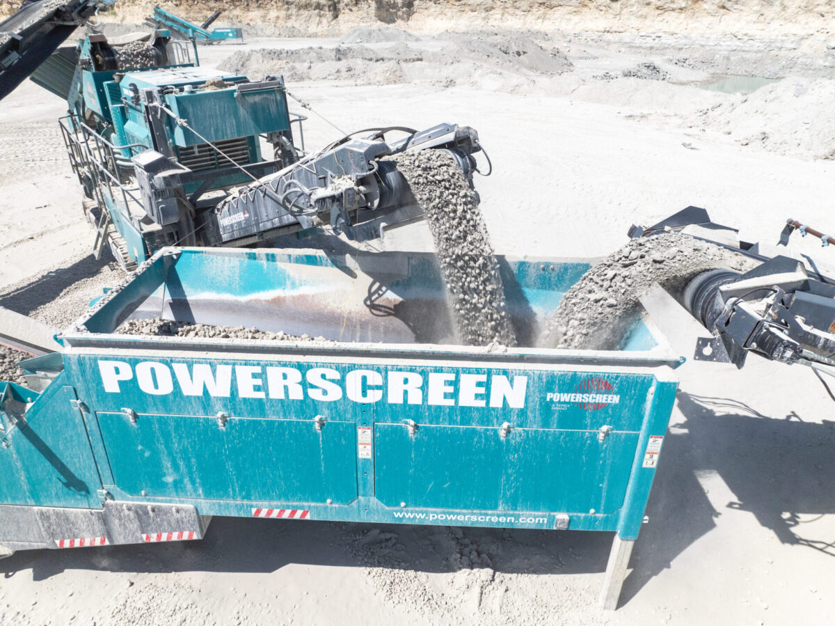 blue machines pouring rocks into another blue machine