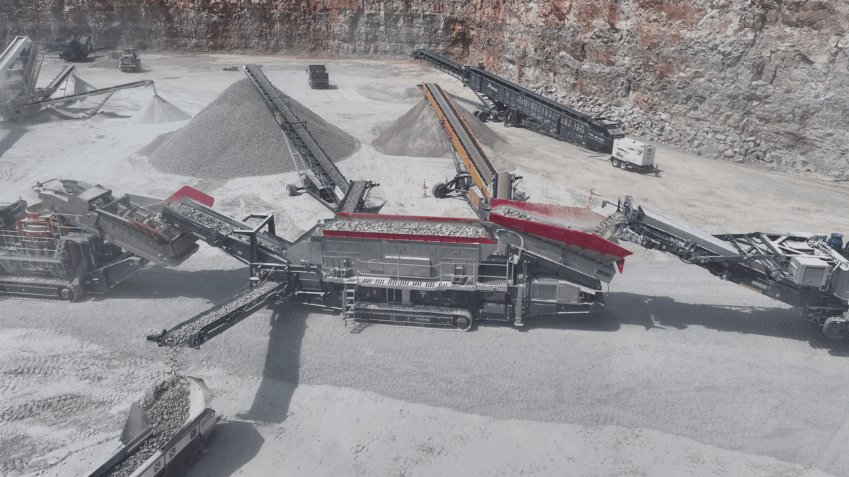 High-capacity MAGNA mobile crushing and screening plant at work in a quarry, efficiently processing rock into aggregate with multiple conveyors and stockpiles.
