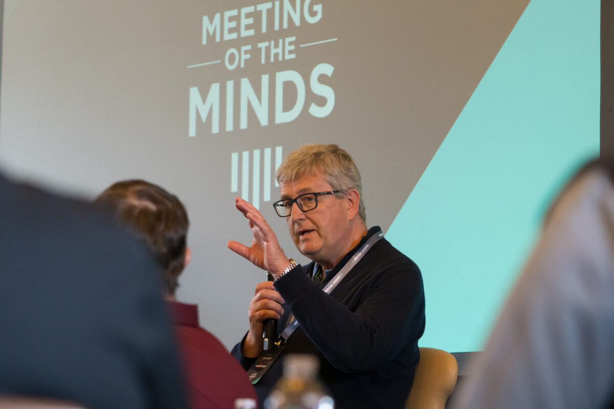 man giving a presentation with hand raised and microphone