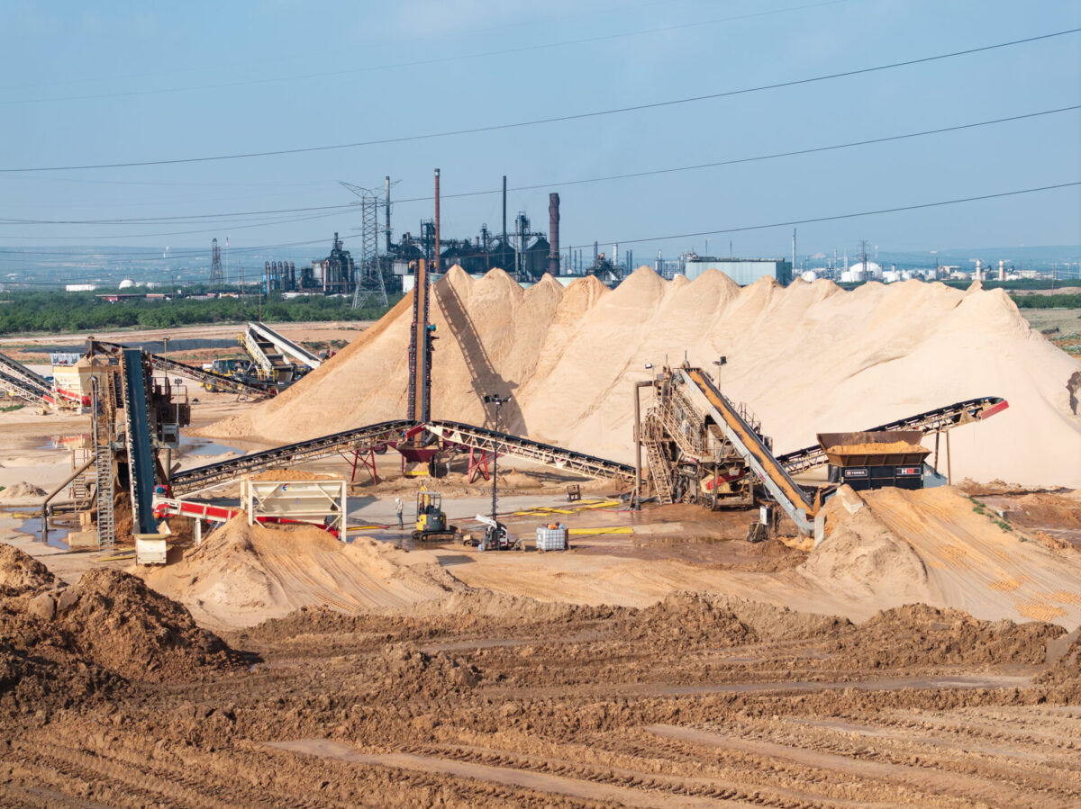 Wide shot of machines working and processing sand