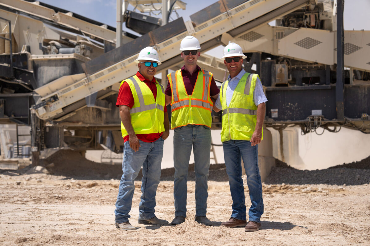 Three men standing in front of Cedarapids CRH1113R 
